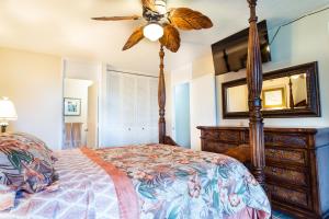 a bedroom with a bed and a ceiling fan at Elegant Turtle Bay Condo in Kahuku