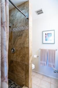 a shower with a glass door in a bathroom at Elegant Turtle Bay Condo in Kahuku
