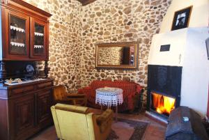 a living room with a fireplace and a table at Complejo rural Aira Sacra-Ribeira Sacra in Vilamelle