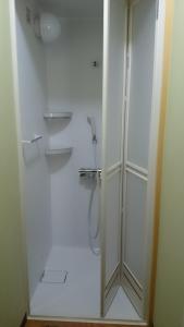 a bathroom with a shower with a glass door at Guest house Minna no Ie in Achi