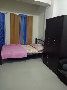 a bedroom with a bed and a dresser and a tv at Vimelzu Mhavic guest room in Manila