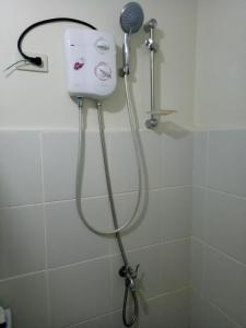 a shower with a shower head in a bathroom at Vimelzu Mhavic guest room in Manila