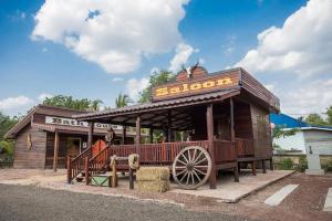 eine Holzstation mit einem Wagen davor in der Unterkunft Stonewood Cowboy City Resort in Ban Krok Duan Ha