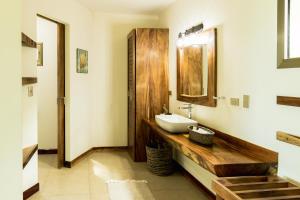 a bathroom with a sink and a mirror at Cocobolo Beach Boutique Hotel in San Juanillo