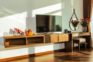 a entertainment center with a large television on a wall at Sun Bay Tuan Chau Hotel in Ha Long