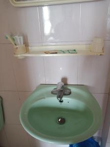 um lavatório verde numa pequena casa de banho em Nhà nghỉ Minh Hạnh em Hoàng Ngà
