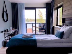 1 dormitorio con cama y vistas a un balcón en Marholmen en Norrtälje