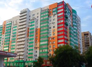 車里雅賓斯克的住宿－InnHome Apartments MOPRa Square 9，一座高大的建筑,有色彩缤纷的窗户,位于城市