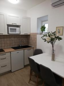 eine Küche mit einem Tisch und einer Blumenvase darauf in der Unterkunft Villa Rajski Dvor 2 in Bol