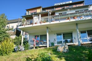 ein Apartmenthaus mit einem Balkon und einem Felsen in der Unterkunft Hotel Restaurant Moselblick in Wintrich