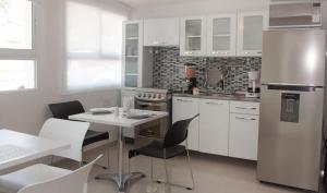 a kitchen with a table and chairs and a refrigerator at Hotel Golden House in Barranquilla