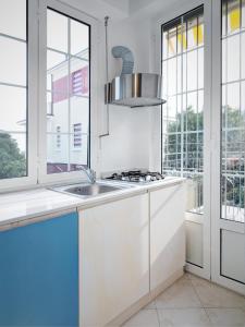 uma cozinha com armários brancos, um lavatório e janelas em Residence Villa Ombrosa em Spotorno