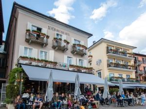 un groupe de personnes assis à l'extérieur d'un bâtiment dans l'établissement Seven Boutique Hotel, à Ascona