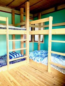 a room with two bunk beds in a house at Obasute Guesthouse Nakaraya in Chikuma