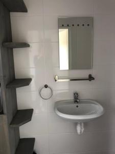 a white bathroom with a sink and a mirror at De goede verwachting in Kamperland +35 photos