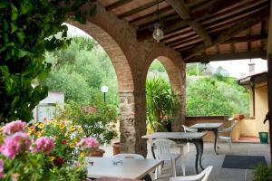 un patio extérieur avec des tables, des chaises et des fleurs dans l'établissement Hotel Girifalco, à Massa Marittima