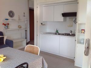 a kitchen with white cabinets and a table at Casa Mary Varenna in Varenna