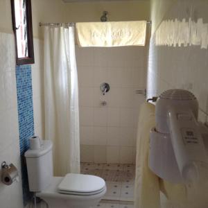 La salle de bains est pourvue de toilettes blanches et d'un lavabo. dans l'établissement AA Lodge Maasai Mara, à Talek