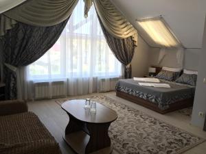 a bedroom with a bed and a table and a couch at Ustyzhna Hotel in Ustyuzhna