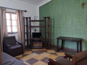 a living room with a tv and a table and a chair at Koito-House calangute guest house in Calangute