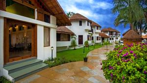 eine Gruppe von Häusern mit Blumen im Innenhof in der Unterkunft Nirali Resorts in Rajkot