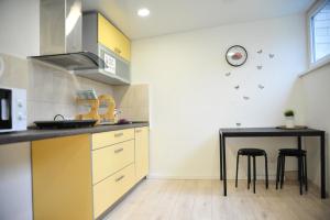 a kitchen with a counter and a table with stools at Savan House "Easy Kaunas" in Kaunas
