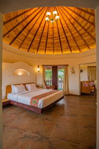 1 dormitorio con 1 cama grande y techo de madera en Nirali Resorts en Rajkot