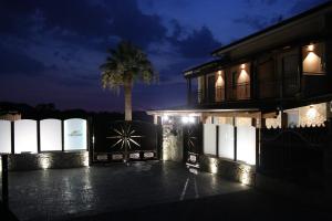 una casa di notte con una palma dietro di B&B Villa Emanuel a Capaccio-Paestum