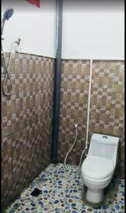 um banheiro com vaso sanitário e chuveiro em Gama Apartments em Dili mais 10 fotografias