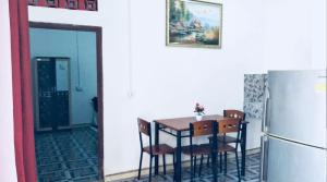 uma cozinha com uma mesa com cadeiras e uma geladeira em Gama Apartments em Dili