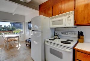 a kitchen with a white refrigerator and a microwave at Periwinkle in Pacific Beach