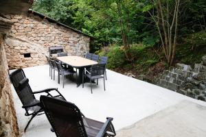 un patio con tavolo, sedie e parete in pietra di Maison en Ardeche a Usclades