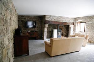 a living room with a couch and a stone wall at Maison en Ardeche in Usclades