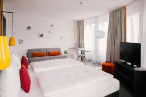 a hotel room with a bed and a television at Vienna House Easy by Wyndham Leipzig in Leipzig