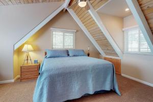 a bedroom with a blue bed in a attic at Dancing Bear Chalet in Lake Arrowhead