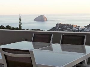 a white table and chairs with a view of the ocean at Villa Iris in Livadi