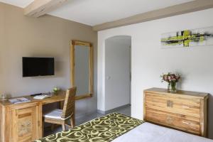 a bedroom with a bed and a desk and a television at Domaine Du Calidianus in Sainte-Maxime