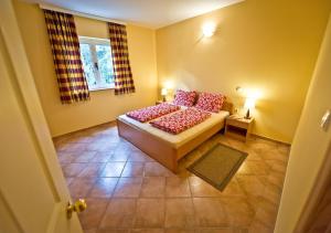a bedroom with a bed with red pillows and a window at Apartmani Ibolja in Promajna
