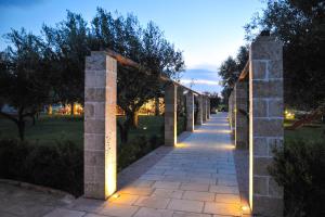 a pathway with lights in a park at night at Gli Ulivi Residence in Leverano