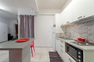 a kitchen with white cabinets and a red plate on a counter at Byron Hotel in Argostoli