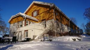 a large wooden house with snow around it at Lepaan Kartanon Vierashuone in Lepaa