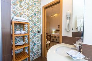 bagno con lavandino, servizi igienici e specchio di B&B Orsini 46 a Napoli