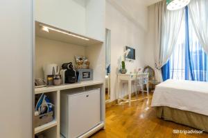 a small room with a bed and a kitchen in it at B&B Orsini 46 in Naples