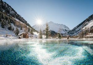 a body of water in the middle of a snow covered mountain at Verwöhnhotel Wildspitze in Sankt Leonhard im Pitztal