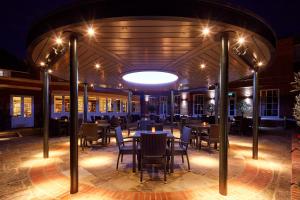 a restaurant with tables and chairs at night at Sir Christopher Wren Hotel in Windsor