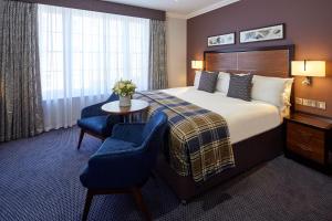 a hotel room with a bed and a table and chairs at Sir Christopher Wren Hotel in Windsor