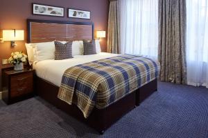 a hotel room with a bed and a window at Sir Christopher Wren Hotel in Windsor
