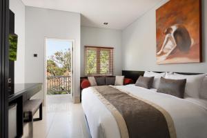 a bedroom with a large bed and a television at The Village Home in Sanur