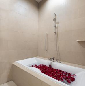a bathroom with a bath tub filled with red roses at The Village Home in Sanur