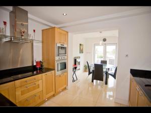 a kitchen with wooden cabinets and a dining room at RossNua in Rosscarbery
